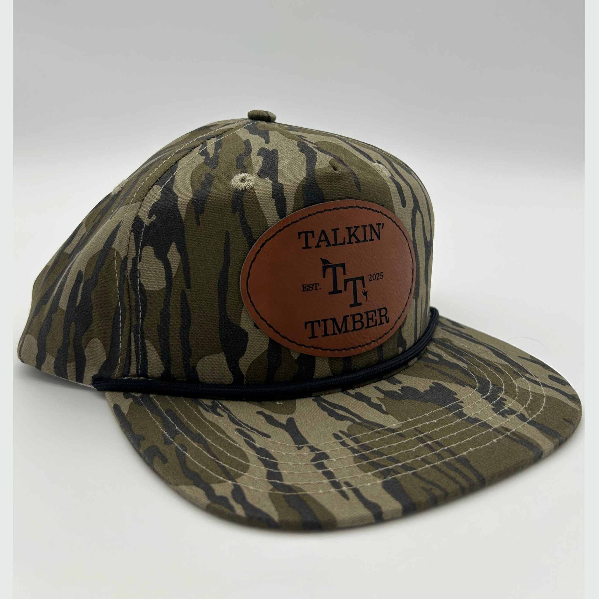 Quartered view of Mossy Oak Bottomland™ rope hat with genuine leather patch, adjustable fit, and vintage camo pattern for duck, turkey, and deer hunters.