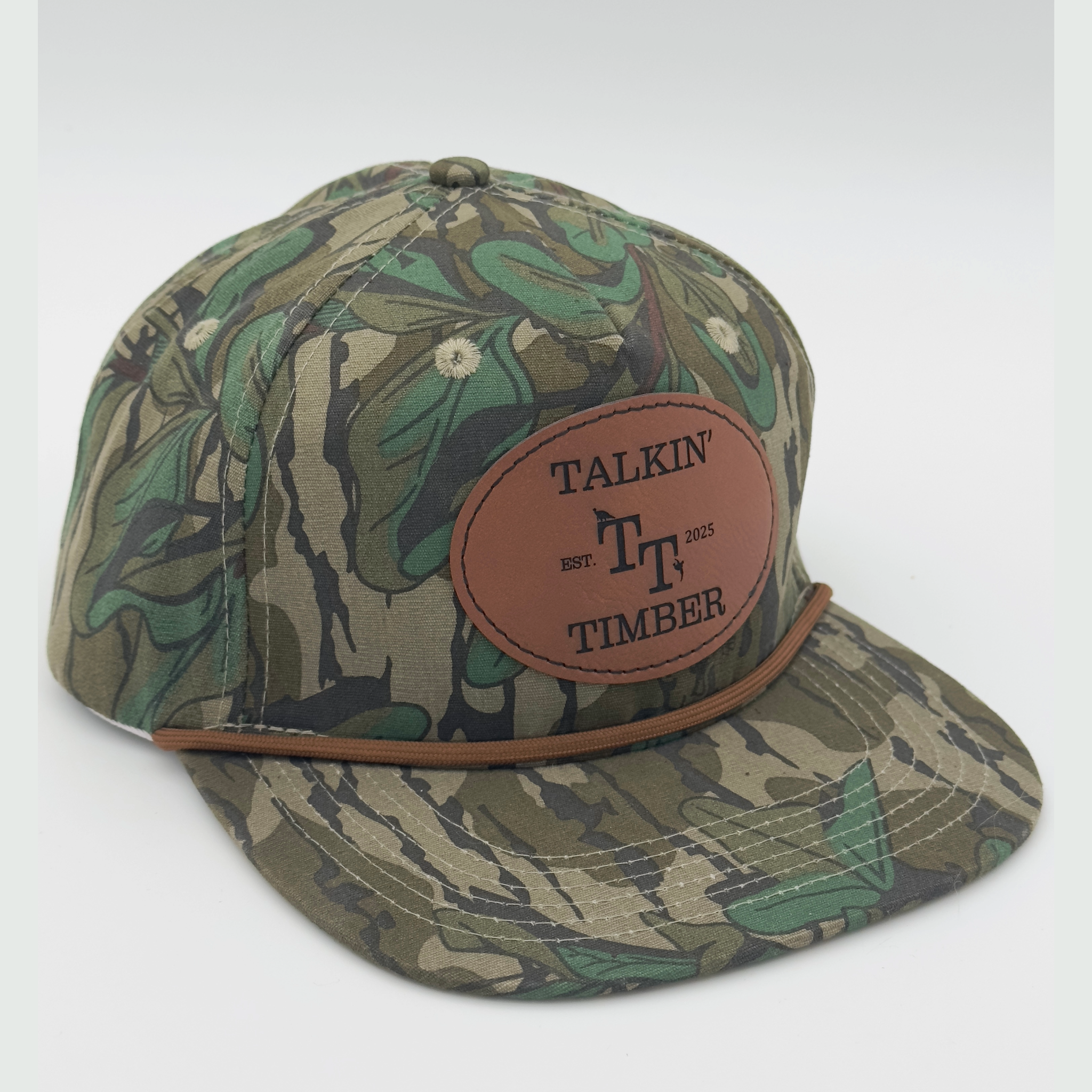 Quartered view of Mossy Oak™ Greenleaf rope hat featuring classic camo pattern and genuine leather patch, perfect for duck, turkey, or deer hunters.