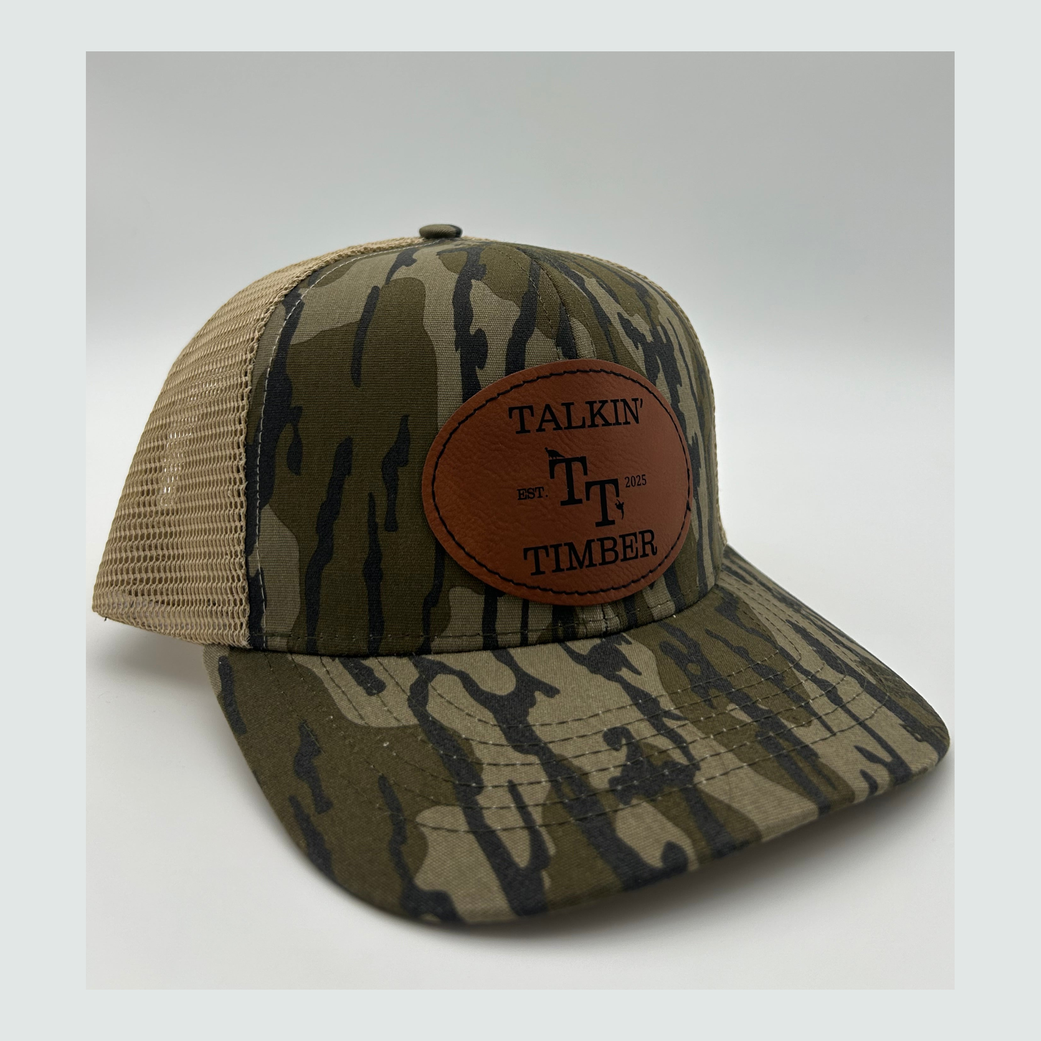 Quartered view of Mossy Oak Bottomland™ mesh back trucker hat with adjustable snapback closure and iconic camo pattern for hunting and outdoor activities.