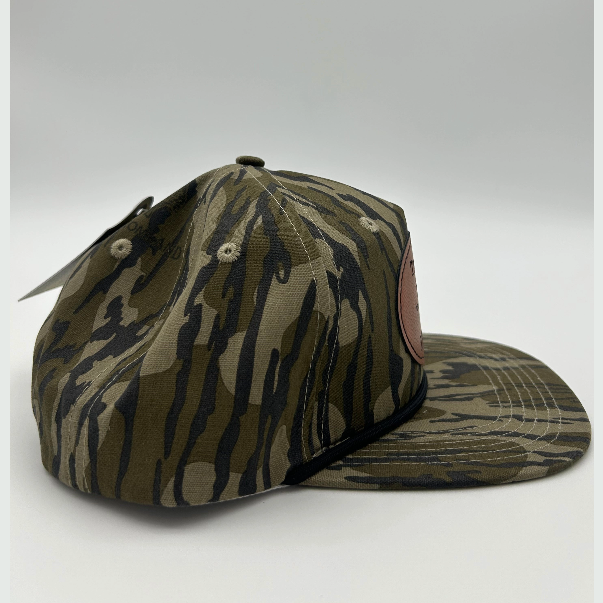 Side view of Mossy Oak Bottomland™ rope hat with genuine leather patch, adjustable fit, and vintage camo pattern for duck, turkey, and deer hunters