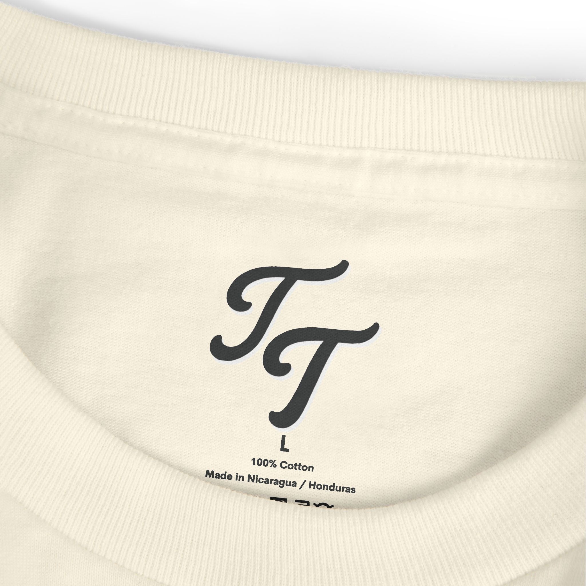 Close-up of a beige sweatshirt with a black logo and text on the label.