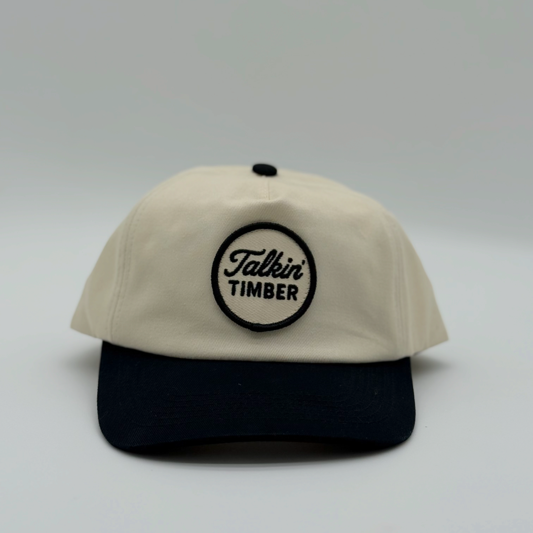 Beige and black cap with 'Talkin Timber' logo on a light gray background