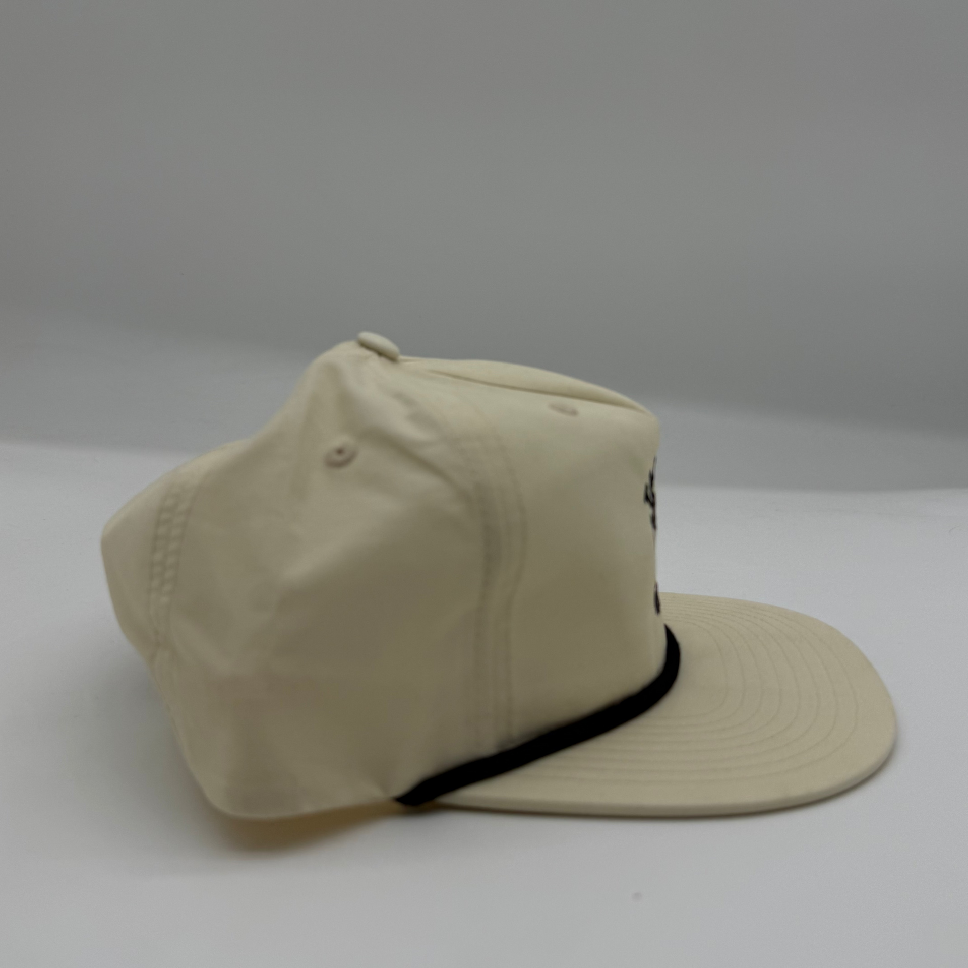 Beige cap with a black rope on a white background