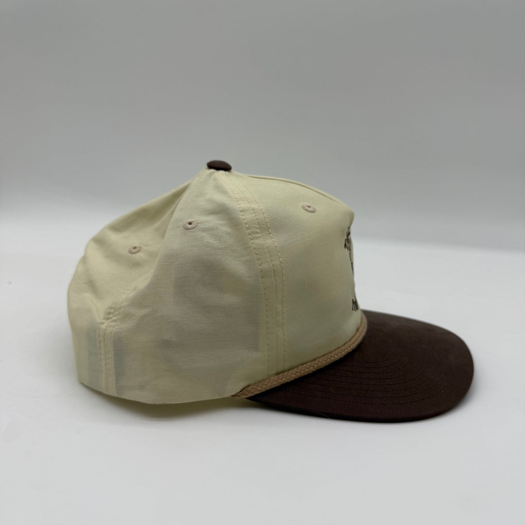 Side view of the Talkin’ Timber Big Buck Cream Hat showing the cream crown, brown flat bill, and tan rope detail.