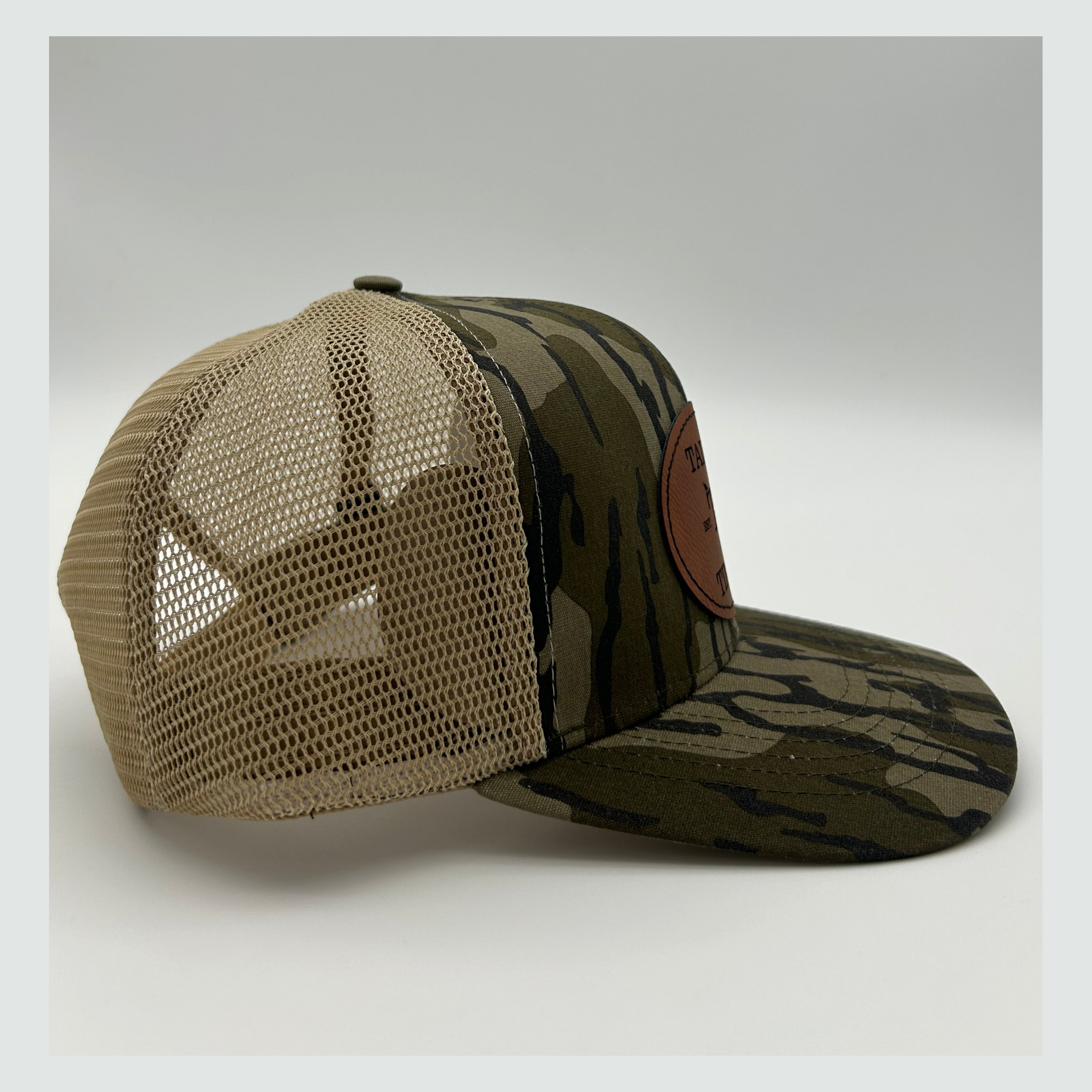 Side view of Mossy Oak Bottomland™ mesh back trucker hat with adjustable snapback closure and iconic camo pattern for hunting and outdoor activities.