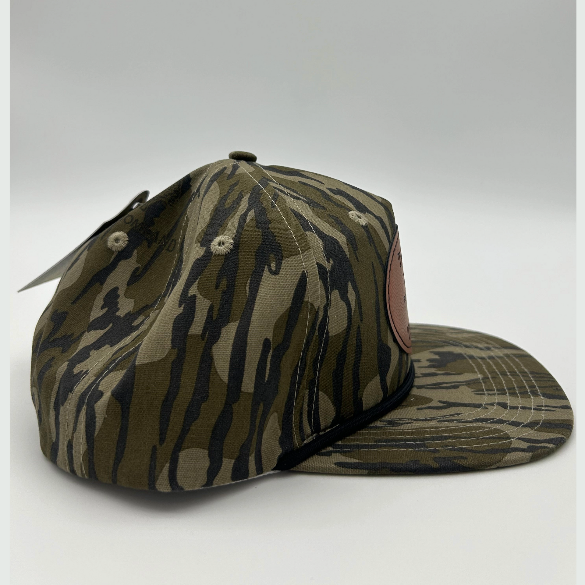 Side view of Mossy Oak Bottomland™ rope hat with genuine leather patch, adjustable fit, and vintage camo pattern for duck, turkey, and deer hunters